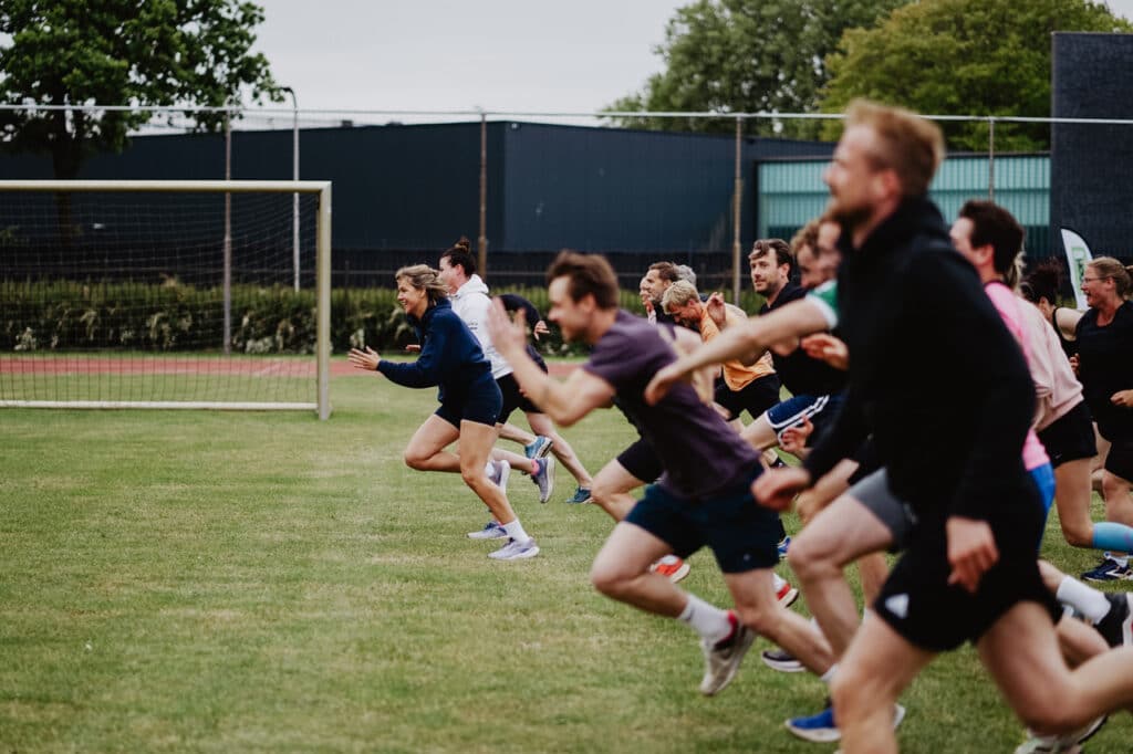 Deelnemers van de Peppergames sprinten over een grasveld